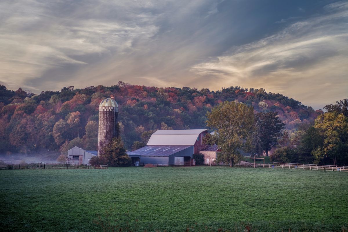 Landwirtschaftliches Wirtschaftsgebäude mit Silo im Herbstlaub