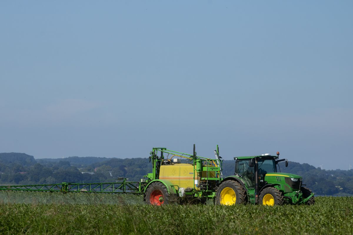 Traktor bei der Feldarbeit unter blauem Himmel